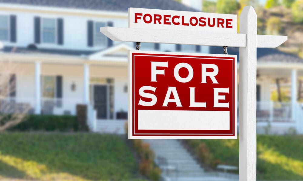 Left Facing Foreclosure For Sale Real Estate Sign in Front of House