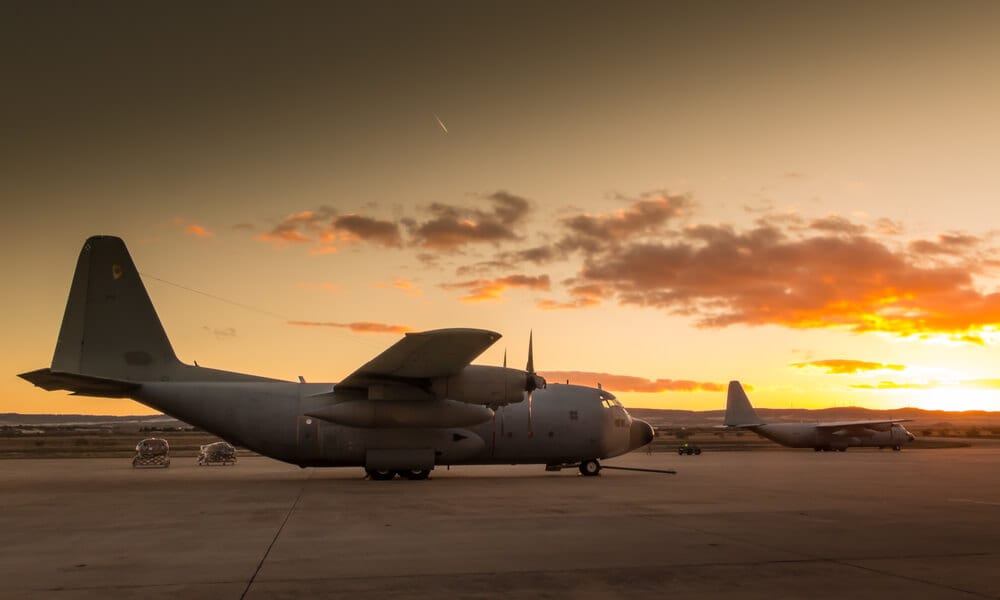 Military aircraft wating to take off on runway during sunset