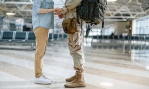 Military husband and wife holding hands before departure in airport