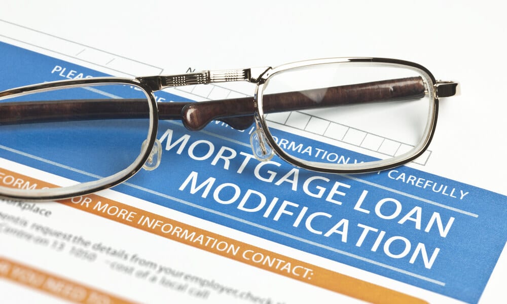 Mortgage loan modification forum with glasses laid atop