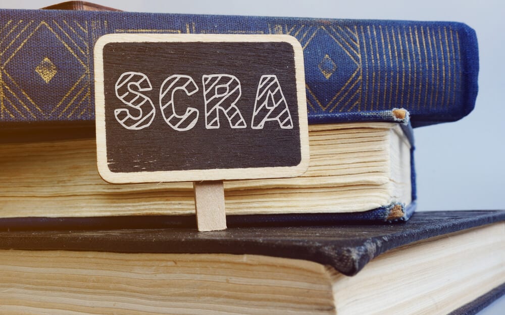 SCRA written on a small sign on top of stack of three books