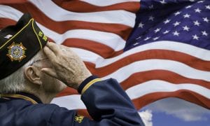 Veteran saluting in front of American flag