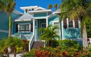 Beautiful New aqua colored Florida House with palm trees and well kept landscaping