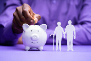 Man putting coin in piggy for his retirement