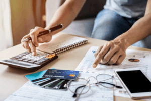 Young woman checking and calculating credit card payments at home.